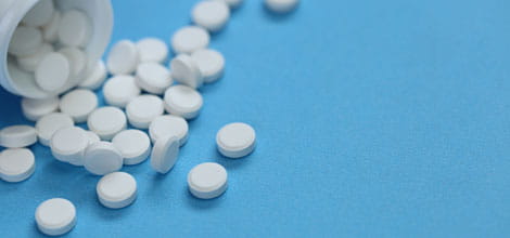 Prescribing, white pills on blue background